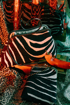 Stylish zebra print bags placed on a textured leopard print surface.