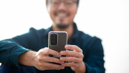 Hands holding a smartphone with blurred person in background