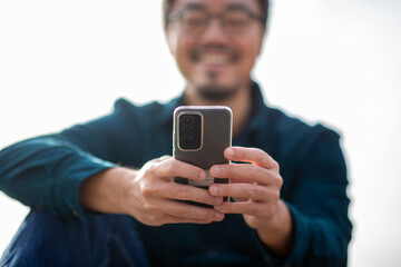 Hands holding smartphone with blurred smiling person in background