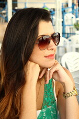 Girl with sunglasses and green t-shirt, looking to the side