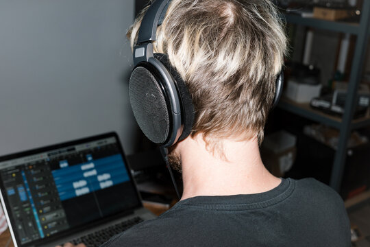 A musician in headphones focusing on audio production 