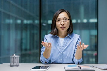 Webcam view, serious focused woman talking to colleagues remotely, using video call on online...