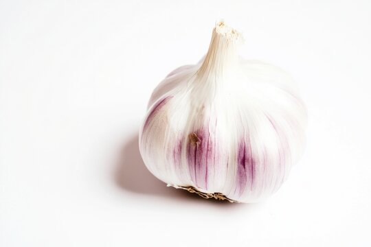 A single garlic clove on a white surface