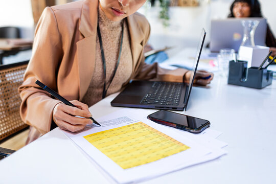 Crop of businesswoman's hand checking data in work meeting 
