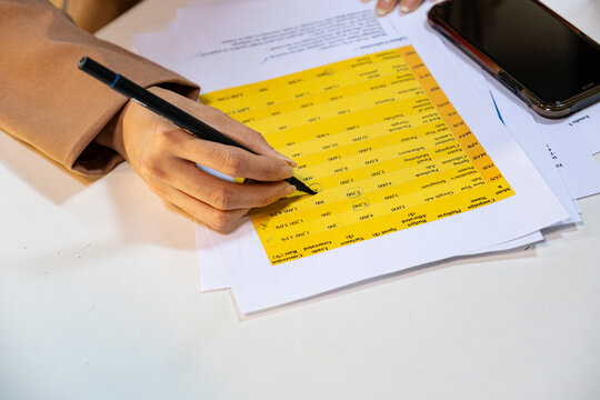 Anonymous woman's hand checking data in work meeting 