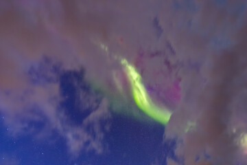 Obraz premium The stunning Northern Lights over Lofoten Islands, Norway, with vivid colors lighting up the night sky above mountains.