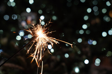 osoba trzymająca zapalone zimne ognie na zewnątrz  w zimowej scenerii © siwyk