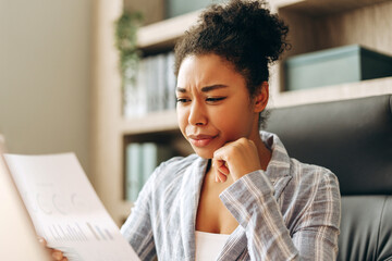 Stressed young manager reading bad news on financial report at office