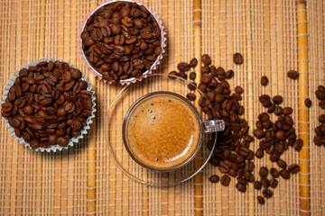 coffee and coffee beans on a straw tablecloth during an afternoon or morning coffee with beans arranged around
