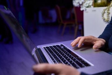 A Focused Hands Actively Typing on Laptop in a Dimly Lit Setting to Enhance Productivity