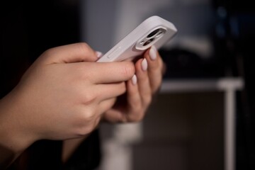 An Intimate Close Up of Hands Firmly Holding a Smartphone in a Soft Dim Light Environment