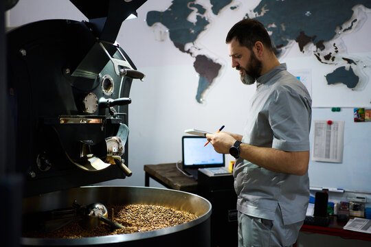 Coffee roaster meticulously records details during the roasting