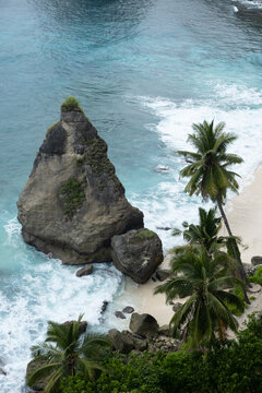 A tropical coastline with a large, rocky outcrop. 