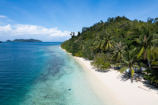 Tropical shoreline with clear blue water and a white sandy beach