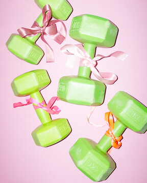 Gym weights workout exercise dumbbells with pink cute silk ribbons 