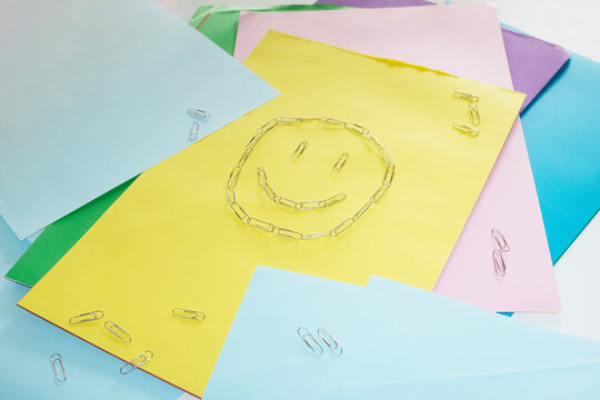 Contemporary style of smile made of office supply paper clips on desk