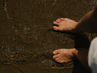 A person enjoying the soothing water on a sandy beach 