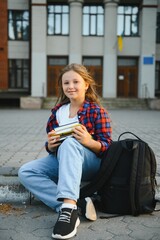 Beautiful schoolgirl with a backpack and books. Back to school