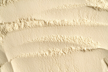 Whey protein powder as textured background, top view