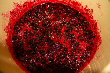 Large pot with blackberry jam boiling in it close up.