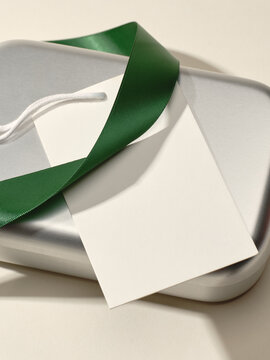Silver gift box with green ribbon and blank tag ready for gifting
