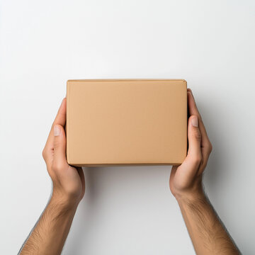 H&auml;nde halten ein neutrales, braunes Paket vor einem wei&szlig;en Hintergrund

