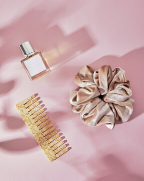 Stylish gold scrunchie artfully displayed with comb and a perfume