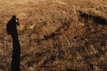 Shadow of a Person on Dry Grass Field
