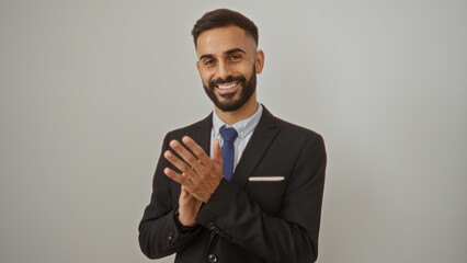 Handsome young man with a beard clapping over an isolated white background, appearing cheerful and professional in formal attire