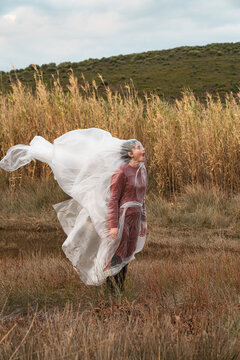 Young woman wrapped in plastic sheet blowing in the wind