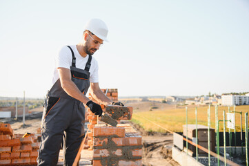 Construction worker man in work clothes and a construction helmet. Portrait of positive male...