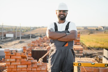 Indian Construction worker man in work clothes and a construction helmet. Portrait of positive male...