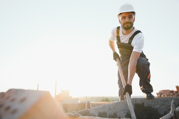 Construction worker in uniform and safety equipment have job on building. Industrial theme
