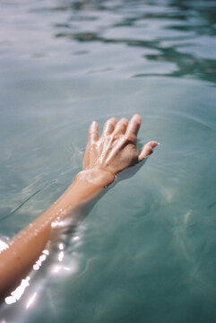 female hand in sea water