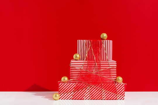 Pile of gift boxes tied with red tulle ribbon with shiny ornaments