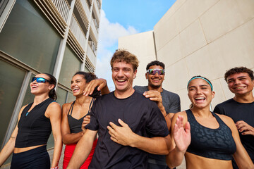 Group of diverse athletes laughing on city street