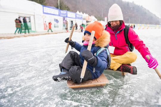 Mother and Child Sledding on an Icy Surface