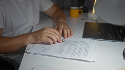 Man working on documents with a laptop at home in the living room.