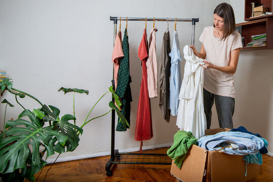 Woman prepares used clothes and accessories for a swap show window