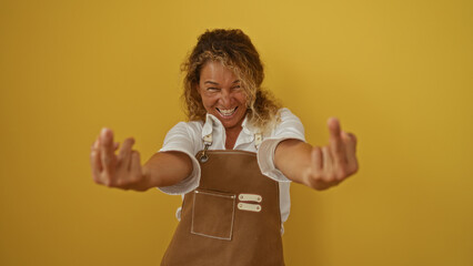 Smiling woman making a rude gesture with both middle fingers on an isolated yellow background