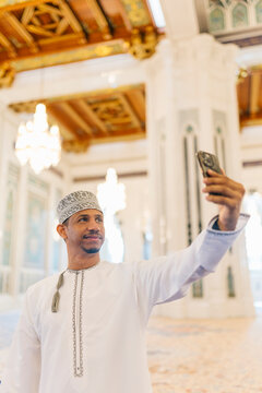 Omani man taking a selfie at the sultan qaboos grand mosque