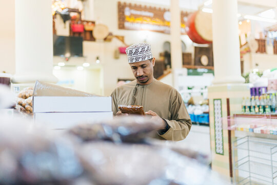 Omani man choosing food products in traditional market