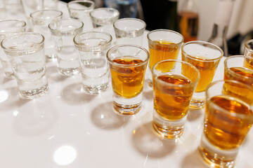 shot glasses lined up on a bar countertop ready for a celebration