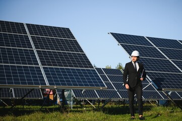 Solar power plant. Man standing near solar panels. Renewable energy