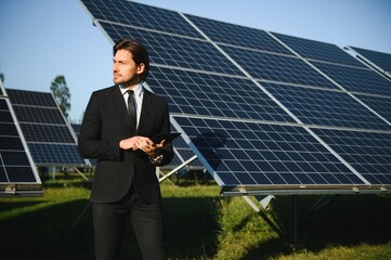 Portrait of a businessman inspecting the operation of solar panels. The concept of investments in...