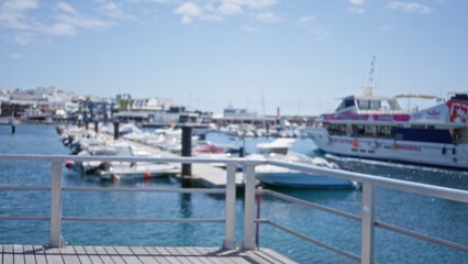Blurred view of marina with docked boats and yachts against defocused background on a sunny day