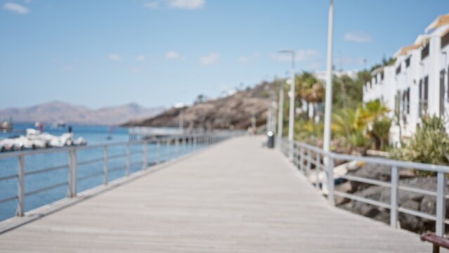 Blurry view of a defocused marina walkway with yachts in the background and a scenic coastal landscape under a clear sky - Powered by Adobe