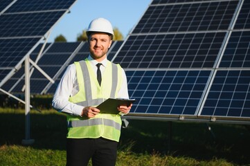 Portrait of a successful businessman or engineer inspecting the operation of solar panels. The...