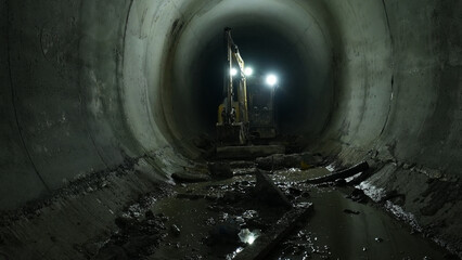 excavator clears tunnel in underground construction
