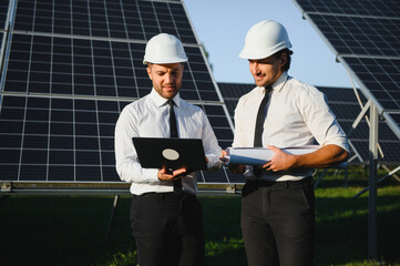 The solar farm, solar panel with two engineers walk to check the operation of the system, Alternative energy to conserve the world's energy, Photovoltaic module idea for clean energy production